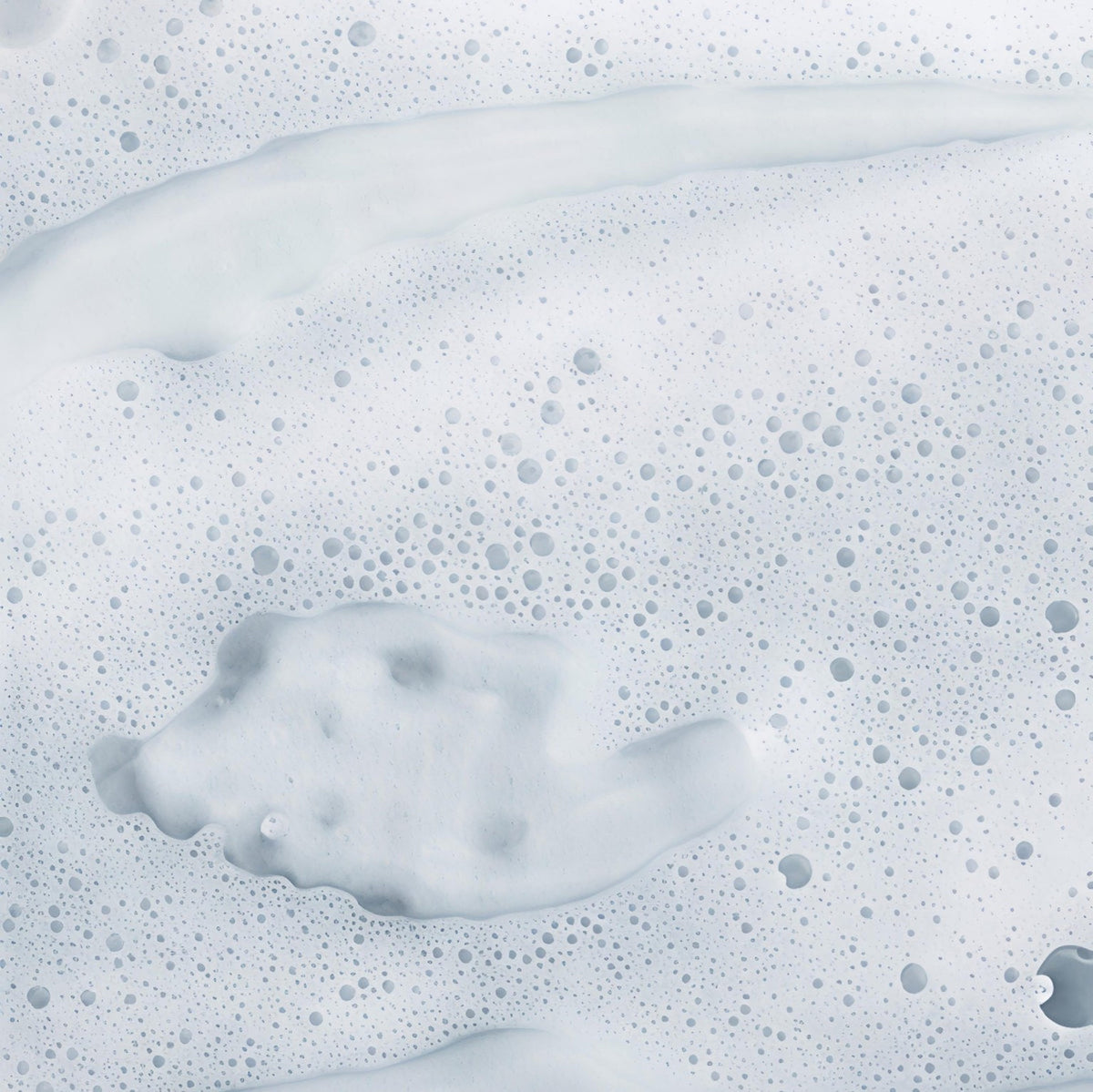 Macro view of a light, fine-pored foam texture with water bubbles.