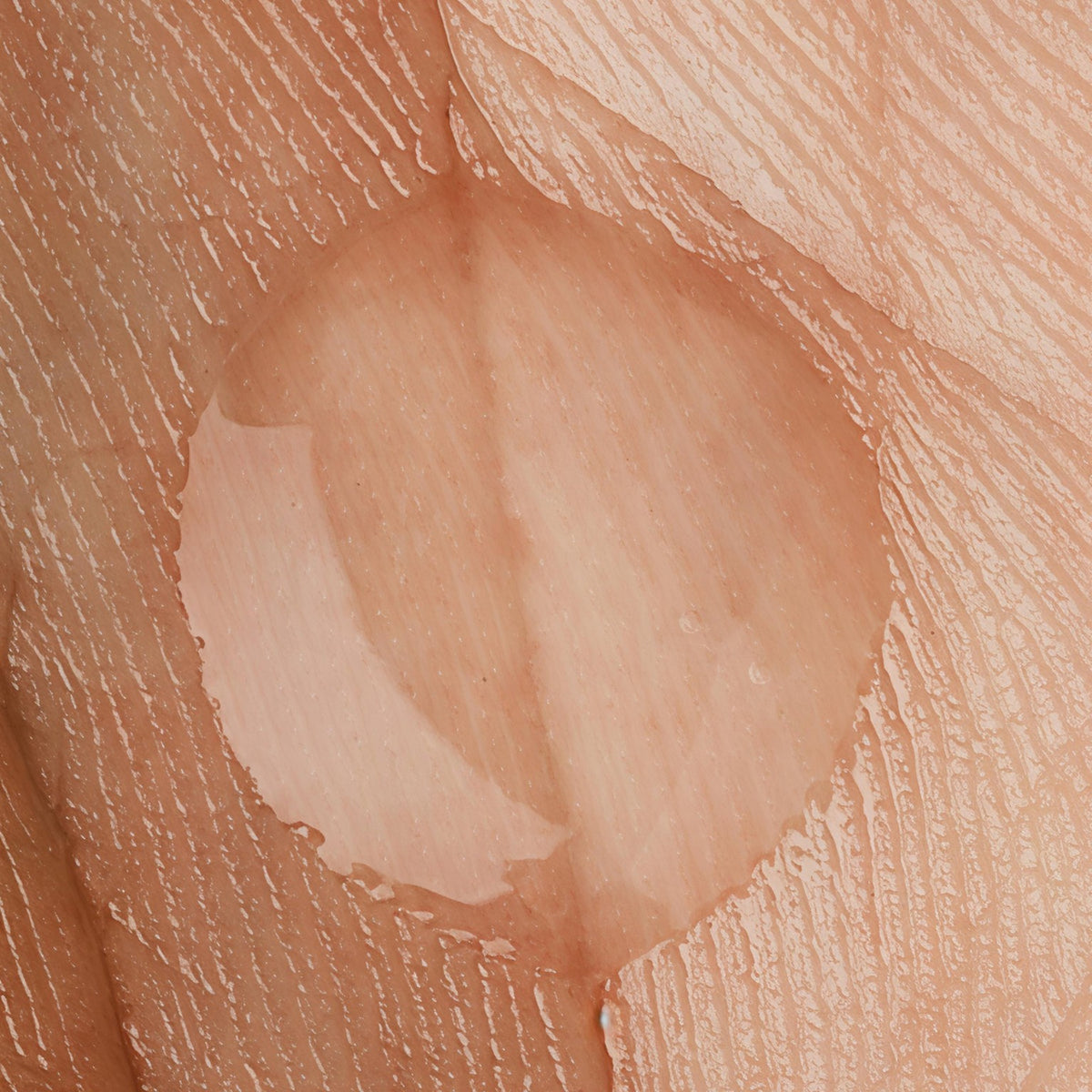 Transparentes Hyaluron-Gel auf natürlicher Hautstruktur in einer Makroaufnahme.