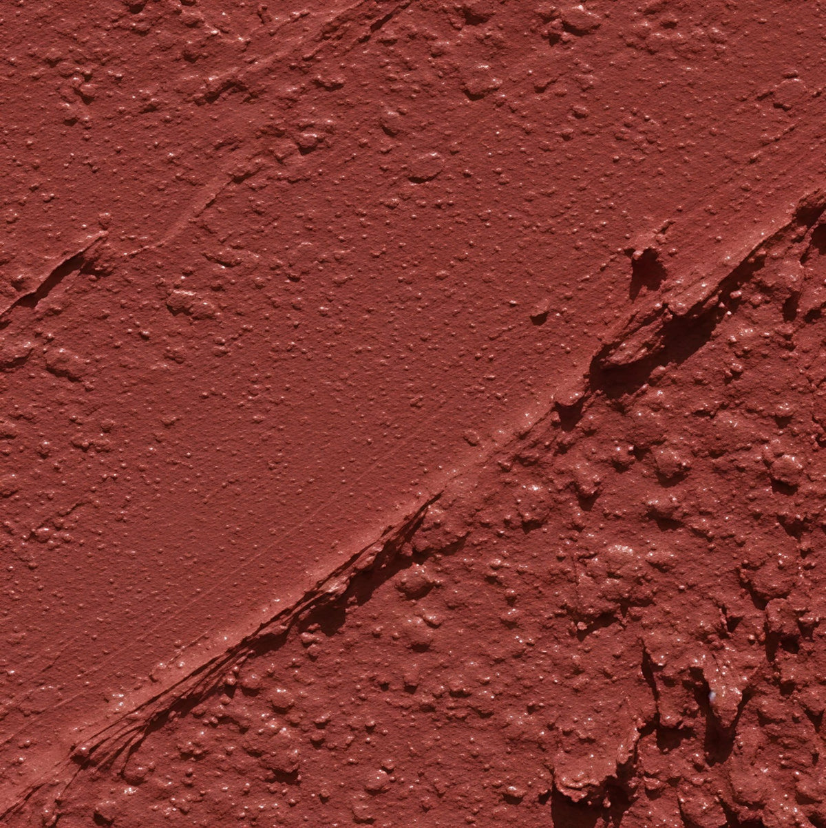 Nahaufnahme eines warm terrakottafarbenen Lippenstift-Texturstrichs.